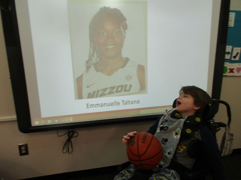 Washington Center student Eliah Peart looks at a picture of his Missouri Women’s Basketball team pen pal, Emmanuelle Tahane, as the class discusses college basketball.