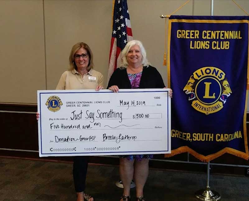 Just Say Something SFP Facilitators, Karen Hyatt (left) and Debbie Pisor (right) accept donation from Greer Centennial Lions Club!
