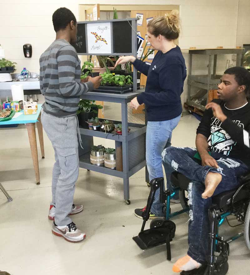 Washington Center Adapted Science Teacher, Jamie Taber and students are pictured selling healthy, organic foods through the school’s environmentally friendly Seagull Sustainability Shop.