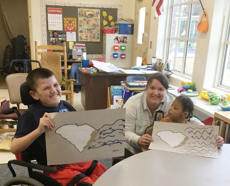 Students in Mrs. Kim Poole’s classroom, Austin Mark and Praisa Taylor show off the maps they created using sand and blue glitter to represent the coastline as they learn about unique geographic features of South Carolina.